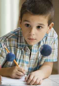Mixed race boy studying the planet model in classroom